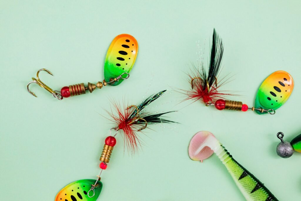 Close-up of vibrant fishing lures and hooks on a green backdrop.